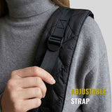 Close-up of a person adjusting a black quilted adjustable strap on a pet carrier sling.