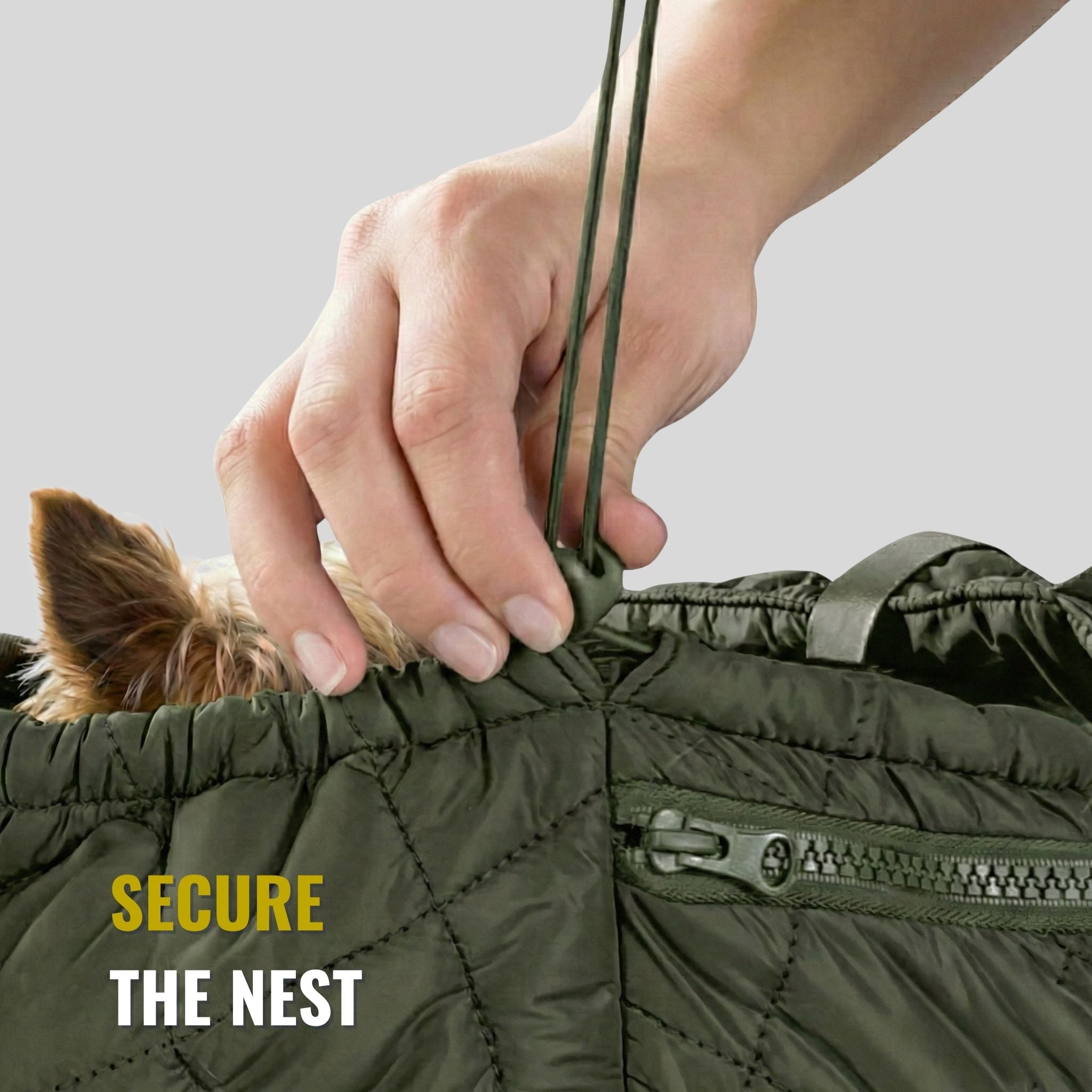Hand tightening drawstring on green quilted pet carrier bag with small dog inside