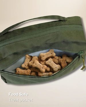 Open front treat pouch of the olive green SUSU Grab & Go dog walking bag filled with dog biscuits, food-safe lining visible