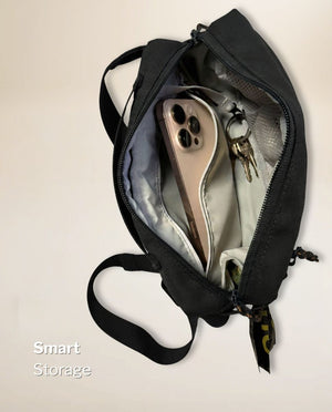 Inside the main compartment of the black SUSU Grab & Go dog walking bag with a large phone in a case and keys on the built-in key clip