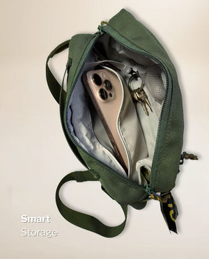 Inside the main compartment of the olive green SUSU Grab & Go dog walking bag with a large phone in a case and keys on the built-in key clip