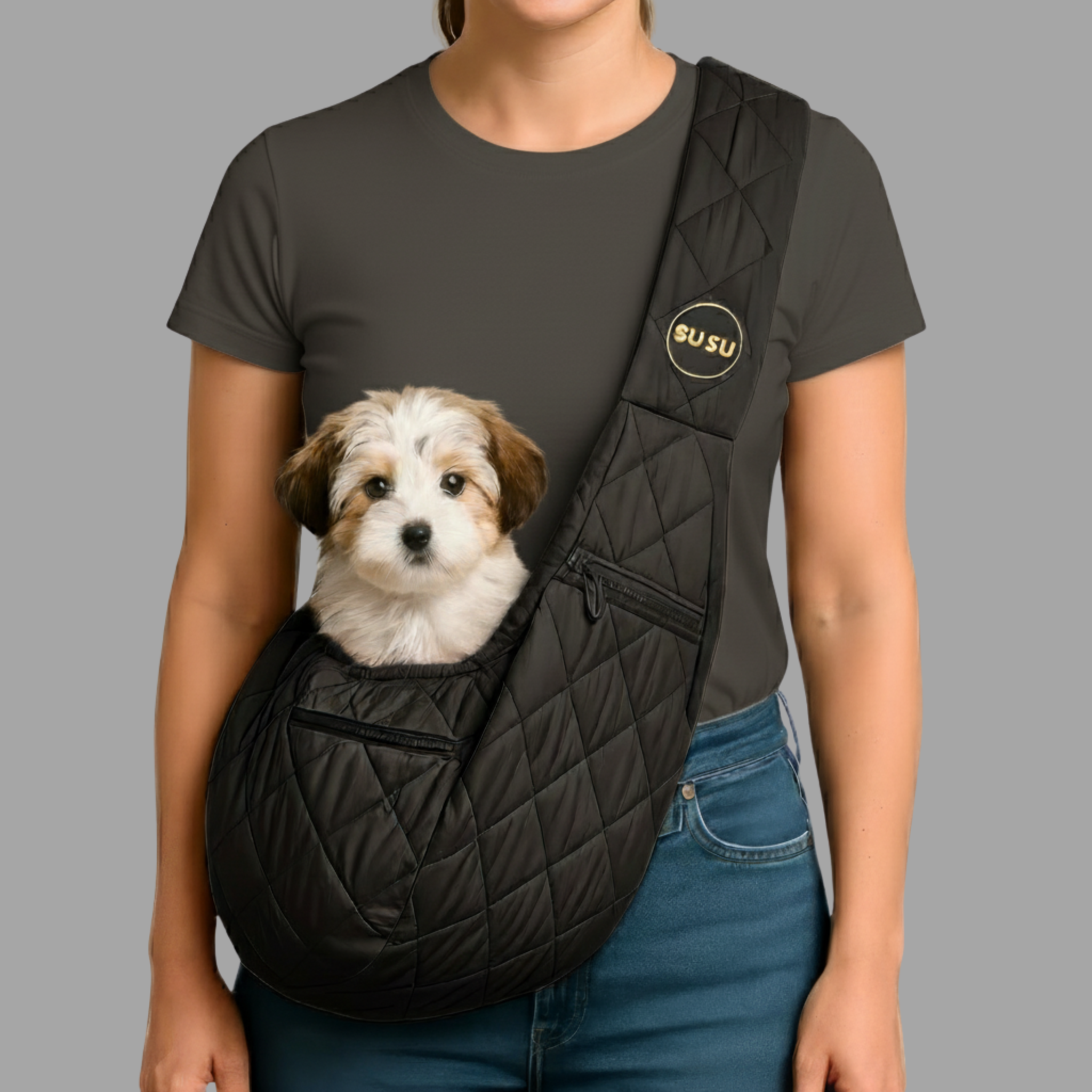 Close-up of a Black SUSU small dog carrier sling worn crossbody with a white puppy sitting comfortably inside against neutral background
